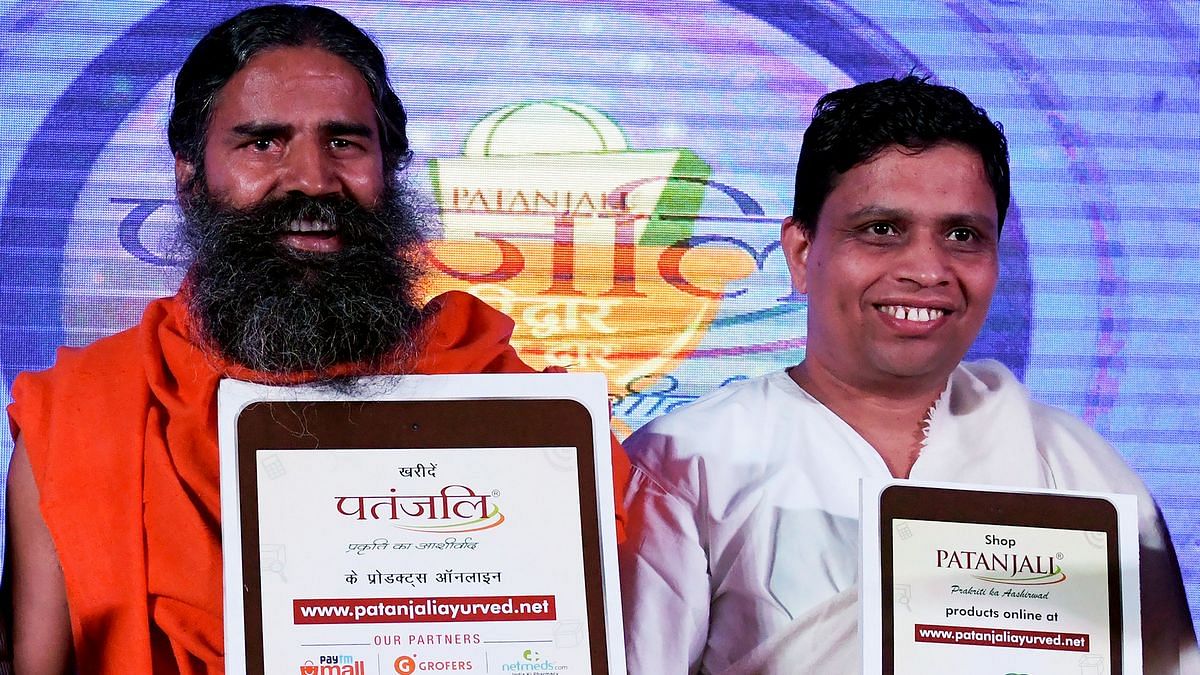 Indian yoga guru Baba Ramdev (L) and Patanjali Ayurveda Managing Director, Acharya Balkrishna, pose for a photo during a press conference in New Delhi on January 16, 2018. India's hugely popular yoga guru on January 16 announced a tie-up of his Patanjali brand with a clutch of e-commerce majors including Amazon, eyeing a slice of the lucrative $1 billion online market for consumer goods. / AFP PHOTO / MONEY SHARMA (Photo credit should read MONEY SHARMA/AFP/Getty Images)