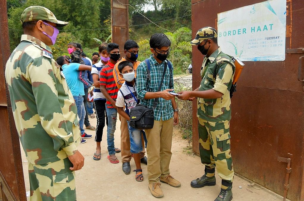 BSF personals wear a mask as they checking the documents of people for India-Bangladesh border haat,