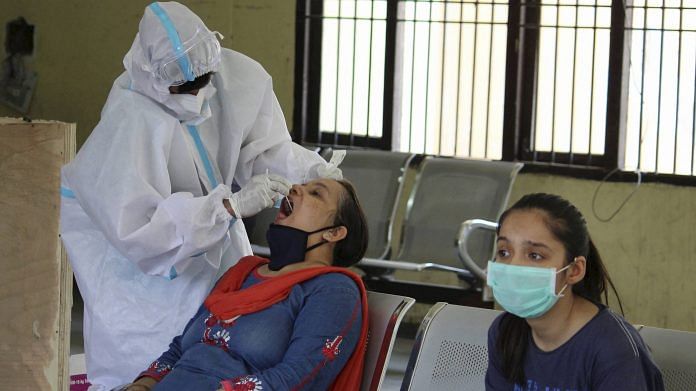 गुरुग्राम में रैपिड एंटीजन के माध्यम से एक स्वास्थय कर्मचारी कोविड -19 परीक्षण के लिए एक महिला का स्वाब नमूना एकत्र करती हुई/फोटो: पीटीआई