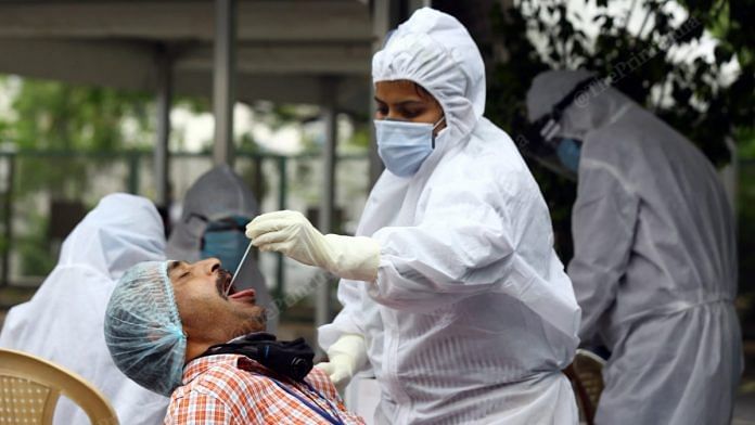 प्रतीकात्मक तस्वीर | एक मेडिकल वर्कर दिल्ली में कोविड-19 टेस्ट के लिए सैंपल इकट्ठा करता हुआ | Suraj Singh Bisht | ThePrint