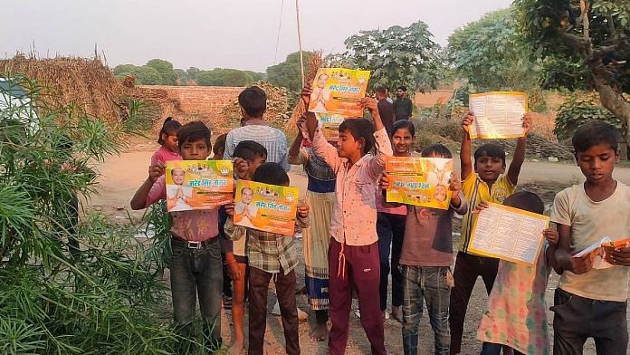 दिमनी में चुनाव प्रचार के दौरान नरेंद्र सिंह तोमर के बेटे द्वारा बांटी गई कैंडी और पोस्टर पकड़े बच्चे | इरम सिद्दीकी/दिप्रिंट