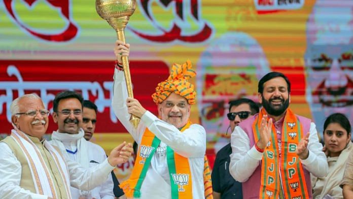केंद्रीय गृह मंत्री अमित शाह करनाल में एक रैली के दौरान गदा लिए हुए हैं. हरियाणा के मुख्यमंत्री नायब सिंह सैनी और पूर्व सीएम मनोहर लाल खट्टर भी साथ में मौजूद | फोटो: एएनआई