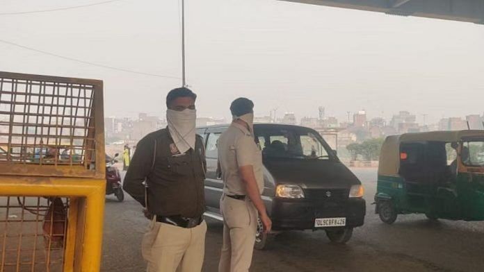 वज़ीरपुर में गश्त पर तैनात पुलिस अधिकारी मुंह पर रूमाल बांधे हुए | मृणालिनी ध्यानी/दिप्रिंट