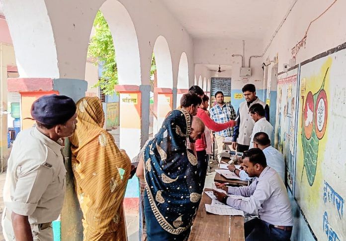 Voters wait in queue to cast their votes for the first phase of the Bihar Assembly elections.